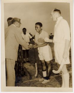 Exchange of gift between Ambassador C. T. O. King and field hockey player