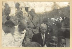 Men in military uniform and men in business suits stand together