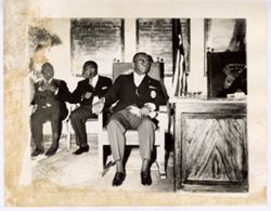 President William V. S. Tubman sits beside podium and listens to speaker