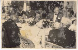 President Tubman speaking with companions at formal dinner table