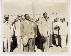President William V. S. Tubman and Paul Magloire pose for portrait as military personnel offer standing salute