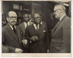 President William V. S. Tubman stands by several men in business suits