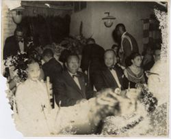 President William V. S. Tubman sits with guests at dinner table at black-tie reception