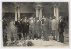 President Tubman stands in a courtyard with dignitaries in or near Seville, Spain