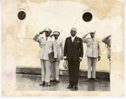 President William V. S. Tubman stands before saluting men and ship