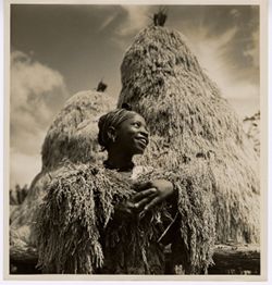 Woman with plant in her arms with large mounds behind