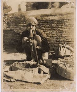 Portrait of Indian man seated amidst baskets