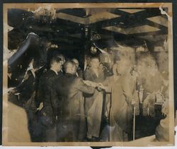 President Tubman and a group of dignitaries place their hands on a book