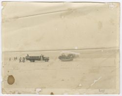 Workers on the beach with a dump truck and a bulldozer