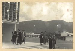 Men in commencement attire gather outside University College