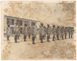 Soldiers stand in rows outdoors