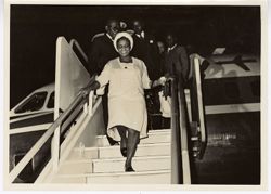 Mrs. Tubman descends from stairs of airplane followed by President William V. S. Tubman