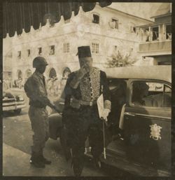 Man in traditional dress leaves vehicle