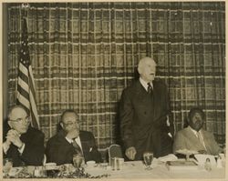 Official gives speech while President William V. S. Tubman and guests sit and listen