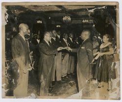President Tubman and a dignitary hold a book as a part of a ceremony