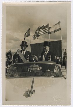 President Tubman standing in open-top vehicle