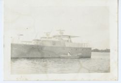 Man in small boat positioned next to ship
