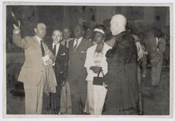 Dignitary and catholic clergyman talk while President and Mrs. Tubman examine the church's interior