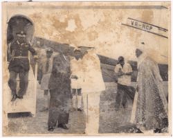 President William V. S. Tubman shakes hands with a dignitary in front of an airplane