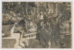 President Tubman walks along a garden path followed by other dignitaries