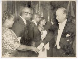 Dignitary shakes hands of guests in a receiving line during formal occasion