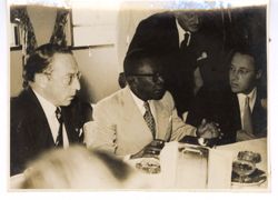 President Tubman talks with dignitaries at a meal