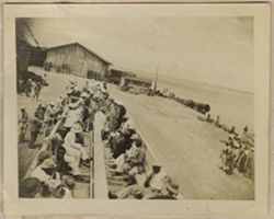 Men sit in open train car at the harbor works in Monrovia