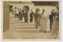 Tribal chiefs in traditional dress escorted into a building