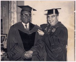 Dr. Peter Sammartino adjusts President William V. S. Tubman's doctoral hood