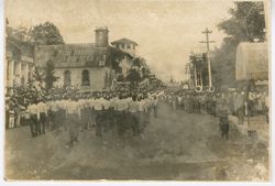 Crowd marches through street in during a parade