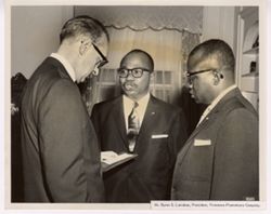 Mr. Byron S. Larabee, President of Firestone Plantation Company stands with two others