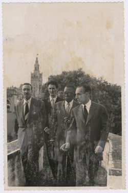 President Tubman walks along an elevated walk way with dignitaries