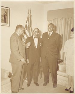 Secretary J. Rudolph Grimes, Ambassador Nathan Barnes, Consul General David M. Thomas and Mrs. Thomas in candid portrait