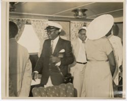 President William V. S. Tubman in captains hat socializing on a ship