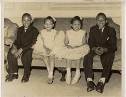 Robert, Sarah, Harriet and George Brewer sitting on a couch dressed up