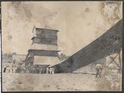 Crowd gathers around an industrial building