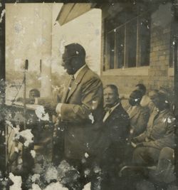 President Tubman speaks into a microphone from behind a lectern