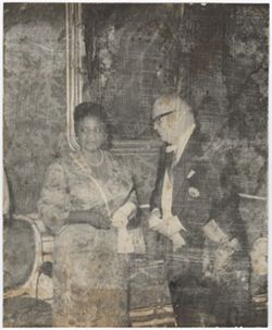 Mrs. Antoinette Tubman in formal attire speaks with official during reception