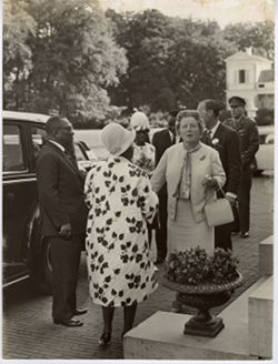 President William V. S. Tubman, Mr. Tubman, and small group mingle outside automobile