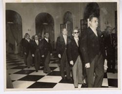 Men in formal attire wait in line
