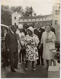 President William V. S. Tubman, Mrs. Tubman, and Coco Tubman stand with guests outdoors