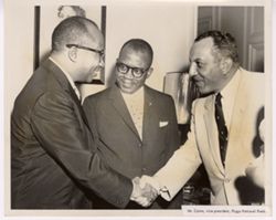 Mr. Corea, Vice President of Riggs National, shakes hands with another