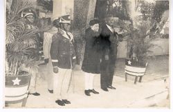 Men in uniform stand together with man saluting