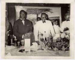 President William V. S. Tubman stands with guest at table during a formal reception