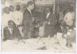President William V. S. Tubman stands to shake hands with guest at dinner party