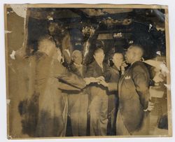 President Tubman and dignitaries hold a book for some sort of official ceremony