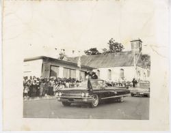 Man waves from car during a parade