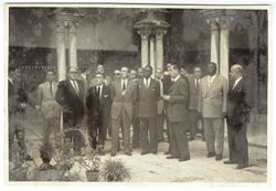 President Tubman stands in a courtyard with dignitaries in or near Seville, Spain