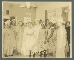 Mrs. Antoinette Tubman stands in gown surrounded by women