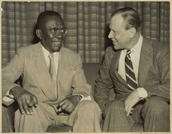 President William V. S. Tubman sits and talks with another man